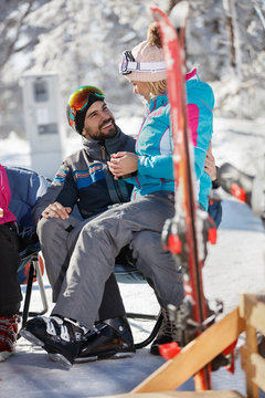 Woman on skiing sitting in man's lap