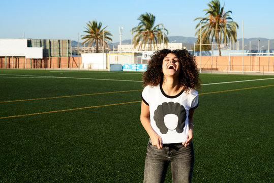 Laughing girl pulling her t-shirt with afro girl.