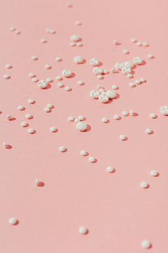 White pills on pink