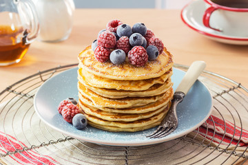 Stack of Pancakes Topped with Powdered Sugar and Chilled Raspberries and Blueberries