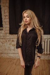 Portrait of beautiful blonde woman wearing in a black wear. Beautiful young woman portrait no smiling posing attractive blond