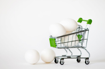 Shopping cart with eggs on a isolated background. Chicken eggs in shop trolley