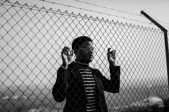 African man behind an iron grid