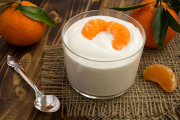 Milk yogurt with mandarin on the  rustic wooden background