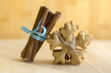 Traditional tasty Czech gingerbreads tied with jute rope, fresh cinnamon with blue bow, Christmas snowflakes and spice on wooden