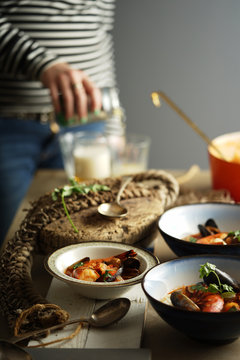Seafood stew served in bowls in a rustic table setting.
