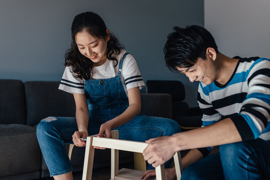Young couple assembling flat-pack furniture