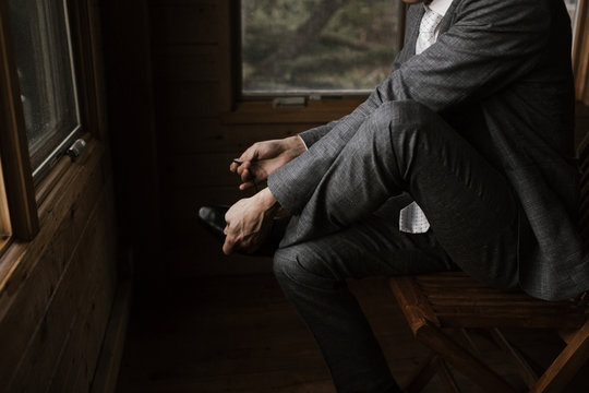 Young Man Putting On Shoes In Suit