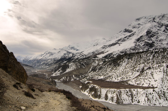 Path and a Frozen River in Severe Snowy Mountains