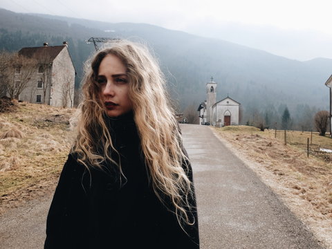 A beautiful woman in front of small church
