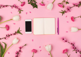 business lady, office, freelance concept. top view of the most important things for businesswoman, there is mobile phone and small clean planner for composing daily life, they are placed among flowers