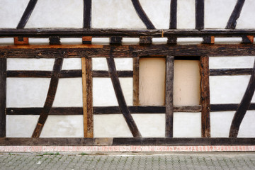 Fachwerkfassade / Die Balkenkonstruktion und das Holzgerüst eines Fachwerkhauses mit zugenageltem...
