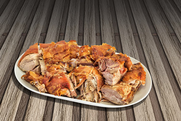 Gourmet Freshly Spit Roasted Tender Pork Shoulder Slices Served On Porcelain Oblong Platter Set On Rustic Slatted Bamboo Mat