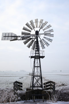 Restored old American windmill in a frozen meadow
