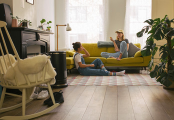 Two woman in a cosy small living room, relaxing.