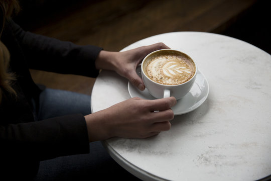 Closeup of hands holding beautiful latte