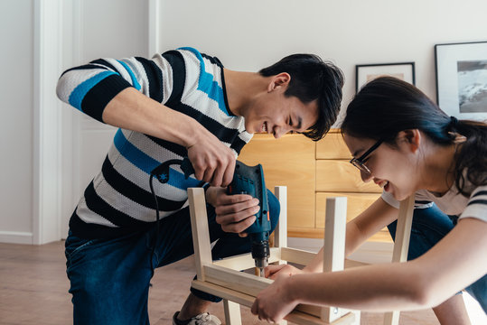 Young couple assembling flat-pack furniture