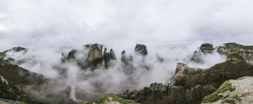 panorama of mystic rockformations of meteora covered in clouds - meteora - greece