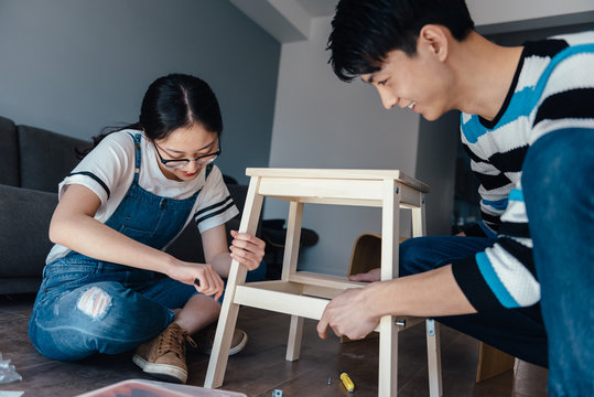 Young couple assembling flat-pack furniture