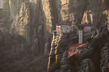 holy monastery built on top of sand pillars at sunset - meteora - greece