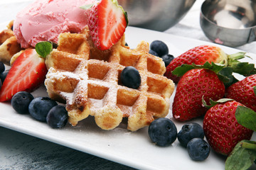 Plate of belgian waffles with strawberry ice cream, and fresh strawberries