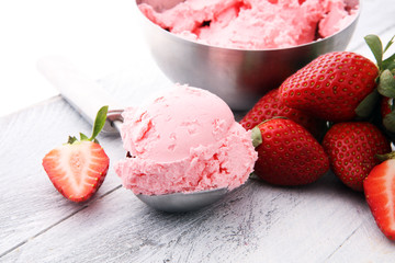 Delicious strawberry ice cream scoop with fresh strawberries on wooden background