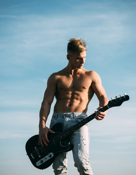 Guitarist man with six pack, ab in jeans outdoor