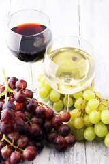 Glasses of wine and grapes on wooden background. red and white wine concept