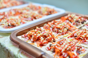 Homemade pizza with mushrooms, tomatoes, cheese and greens in iron square tray on wooden vintage background