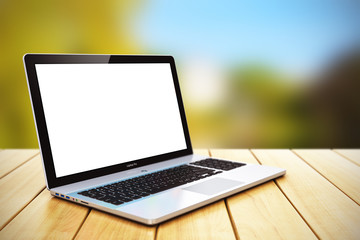 Blank laptop on wooden table outdoors