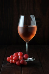 Glass of rose wine and red grapes.