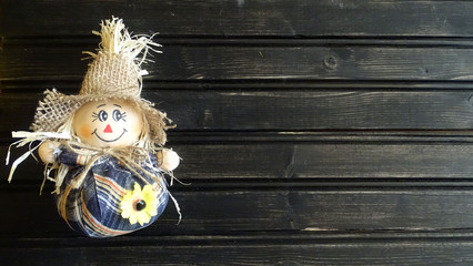 Scarecrow with a straw hat and a wooden background. 