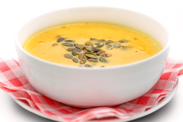 pumpkin soup with seeds in white bowl, hokkaido soup