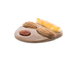 Melted milk chocolate circle with two almonds, pineapple and berry, isolated on white background.