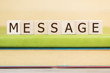 Message word built with letter cubes on green book