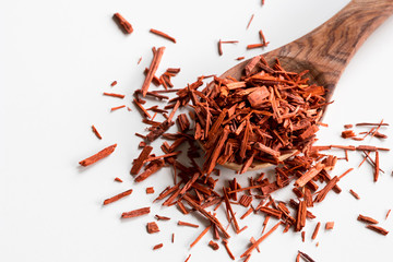Sandalwood pieces on a wooden spoon on white background