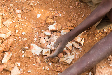 Ugandan child's hands breaking rocks into small slabs for his or her foreman. Shot in Uganda in...