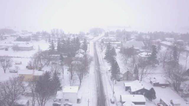 Aerial shot flying slowly over a small town during a blizzard