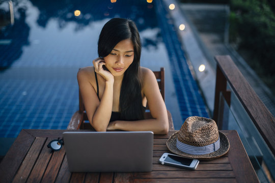 Woman working on laptop on seaside