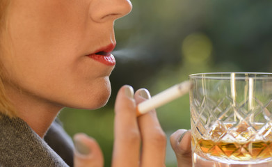 Mujer fumando un cigarrillo y tomando whisky  - obrazy, fototapety, plakaty