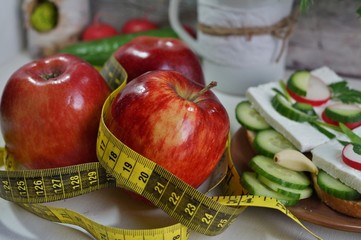 Diet - slimming .Weight loss concept with red apple, vegetables and dairy products
