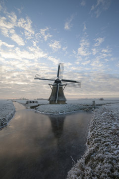 Old Dutch windmill at sunrise in winter