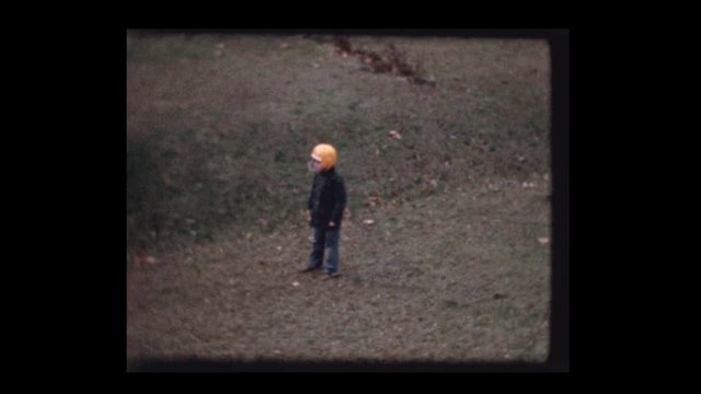 1959 7 year old  Little boy wearing football helmet play catch with football in backyard