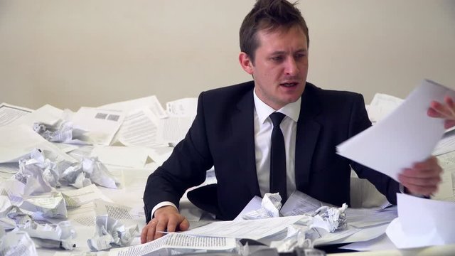 the man in the office drowning in paper