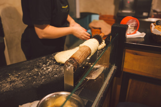 The hands of a female baker cook trdelnik or Trdlo national treat in the Czech Republic in winter