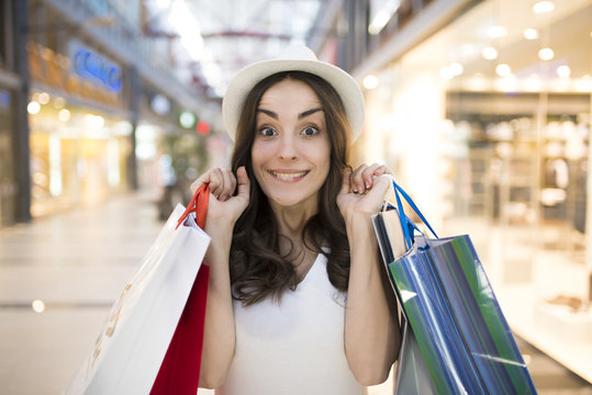 Smiling woman with shopping bags in the big mall