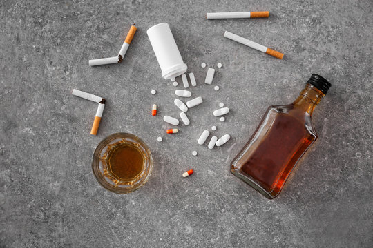 Composition with alcohol, cigarettes and drugs on table. Concept of bad habits