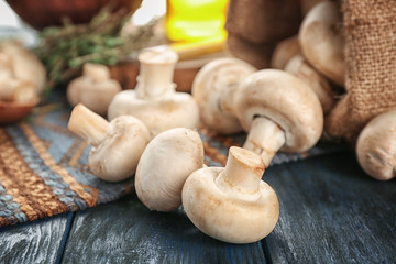 Fresh champignon mushrooms on wooden table