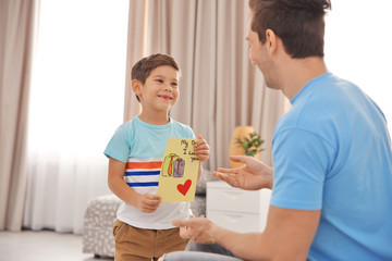 Obraz na płótnie Canvas Little boy greeting his dad with Father's Day