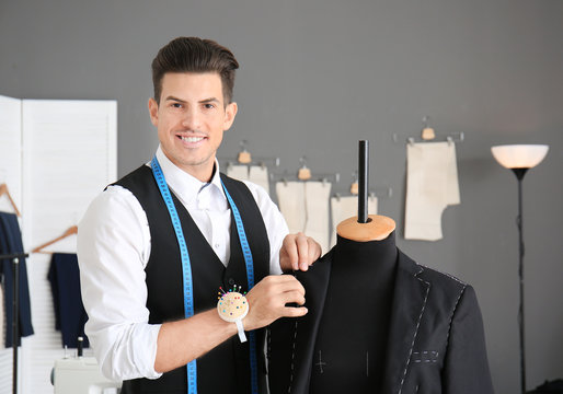 Young man tailoring formal suit in atelier